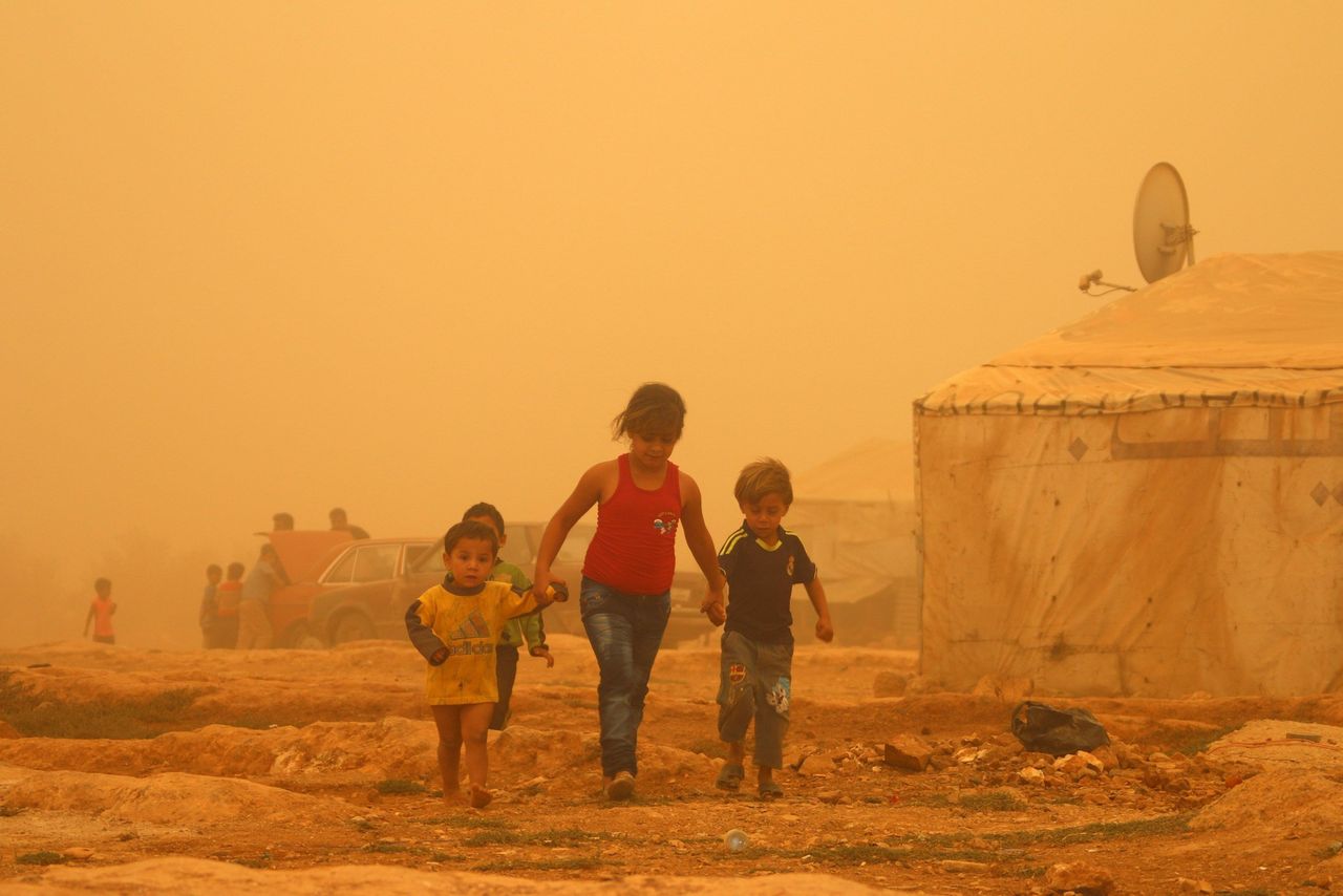 <p>Syrian children walk amid the dust during a sandstorm on Sept. 7, 2015 at a refugee camp on the outskirts of the eastern Lebanese city of Baalbek. </p>