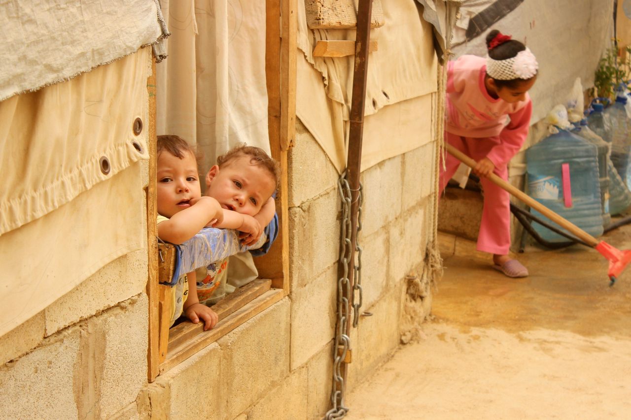Syrian refugee children look on from a window during a sandstorm at a refugee camp near the Bekaa Valley village of Taalabaya, on Sept. 8, 2015.
