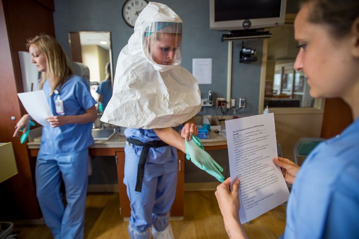 <p>Cassandra Clark puts on protective gear during a weekly drill for Ebola preparedness at the Special Diseases Containment Unit at the University of Minnesota on Thursday, June 25, 2015 in Minneapolis, Minnesota.</p>