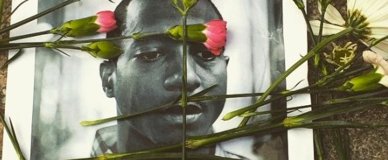 Flowers are scattered across a photo of Kalief Browder, who took his own life in June at the age of 22.