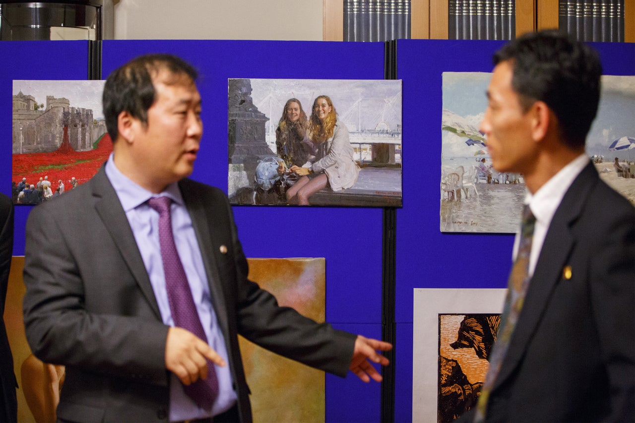 An art exhibition at the North Korean embassy in London. Center, a painting of two Western girls on a London street.