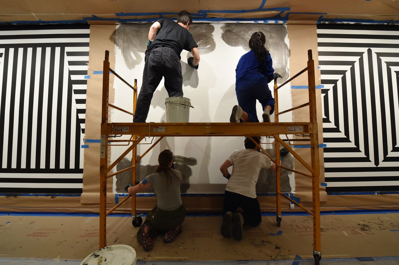 Drafters Gabriel Hurier (L, top), Krysten Koehn (R, top), Sarah Heinemann (L, bottom) and Tim Wilson (R, bottom) apply the first of ten coats of paint to a panel of Sol LeWitt's 1982 "Wall Drawing #370." STAN HONDA/AFP/Getty Images)