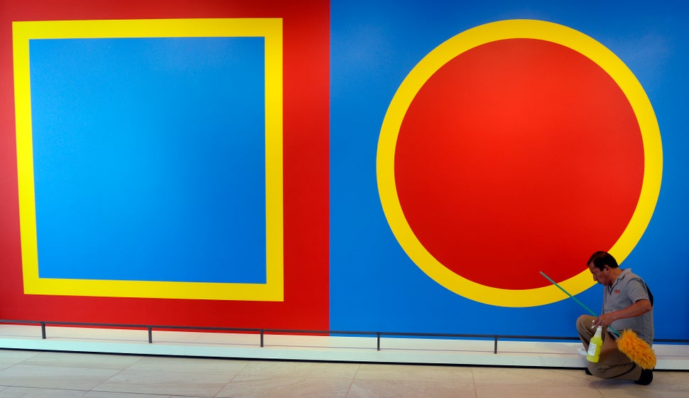 Hotel employee Oscar Aroche shines the railing underneath the "Wall Drawing #397" artwork conceived by Sol LeWitt at The ART,