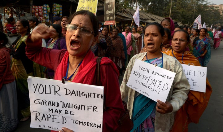 <span>Women's rights activists carry posters as they shout slogans during a protest march against the gangrape and murde