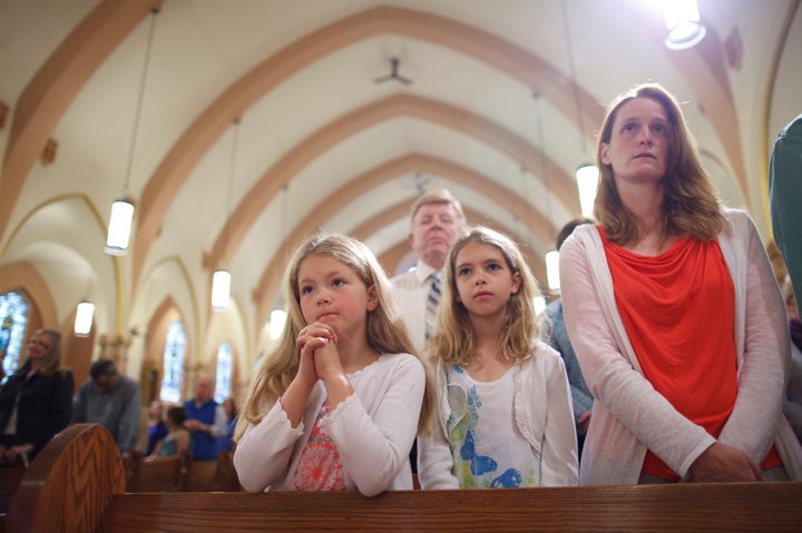 Leslie Baker, left, 8; Meredith Baker, 9; and Monica Baker, right, all of Franklin, attended Sunday Mass at Saint Mary Catholic Church in Franklin, Mass. on May 25, 2014. 