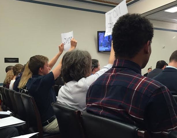 Stanford students hold up signs to voice their objections at a hearing on the Safe Campus Act, which they say will prevent students from reporting sexual assaults.