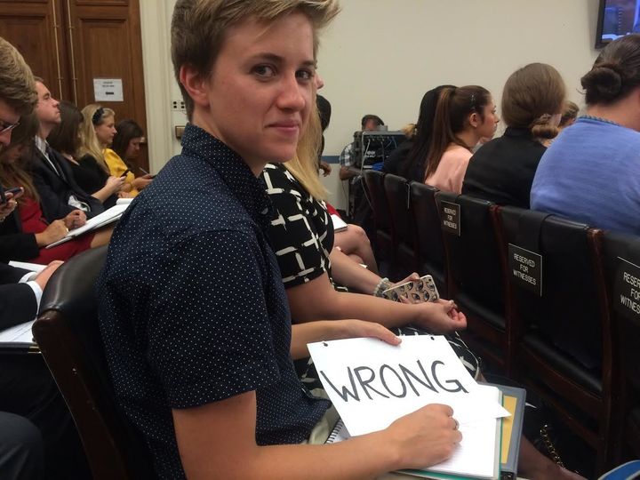 A Stanford University student at a House Education and the Workforce Committee hearing holds a sign to oppose some witnesses' remarks.