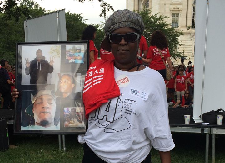 Margaret Eaddy of Hampton, Virginia, holding up photos of her son, Jonathan, who was shot in the head in 2014.