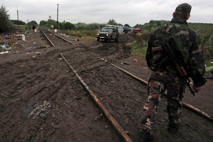 Soldiers of the Hungarian army and police officers stand at the rail tracks at the Hungarian-Serbian border near Roszke on Se