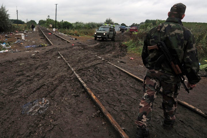 Soldiers of the Hungarian army and police officers stand at the rail tracks at the Hungarian-Serbian border near Roszke on Sept. 11, 2015.