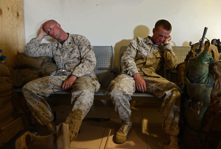 In this photograph taken on October 26, 2014, US Marines rest on benches as they prepare to withdraw from the Camp Bastion-Leatherneck complex at Lashkar Gah in Helmand province, Afghanistan.