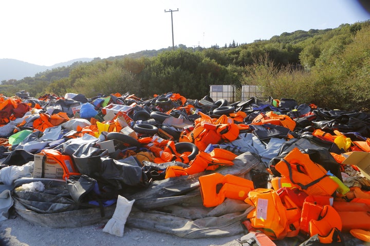  A huge pile of life jackets, other inflatable devices and inflatable rubber dinghies that were used by the refugees com