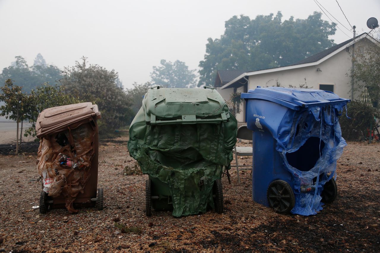 Melted garbage containers damaged by the wildfire sit near homes in Middletown, California, Sept. 13, 2015. 
