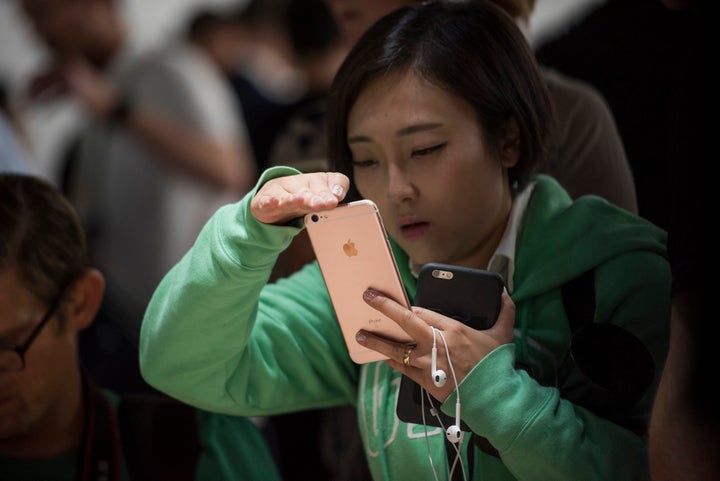 A woman examines the iPhone 6S Plus smartphone after Apple's special event on San Francisco, California, on Sept. 9, 201