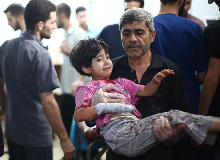 A Syrian child is carried at Sahra Hospital on September 11, 2015 after Syrian regime forces stage an airstrike in Douma district of Damascus, Syria.