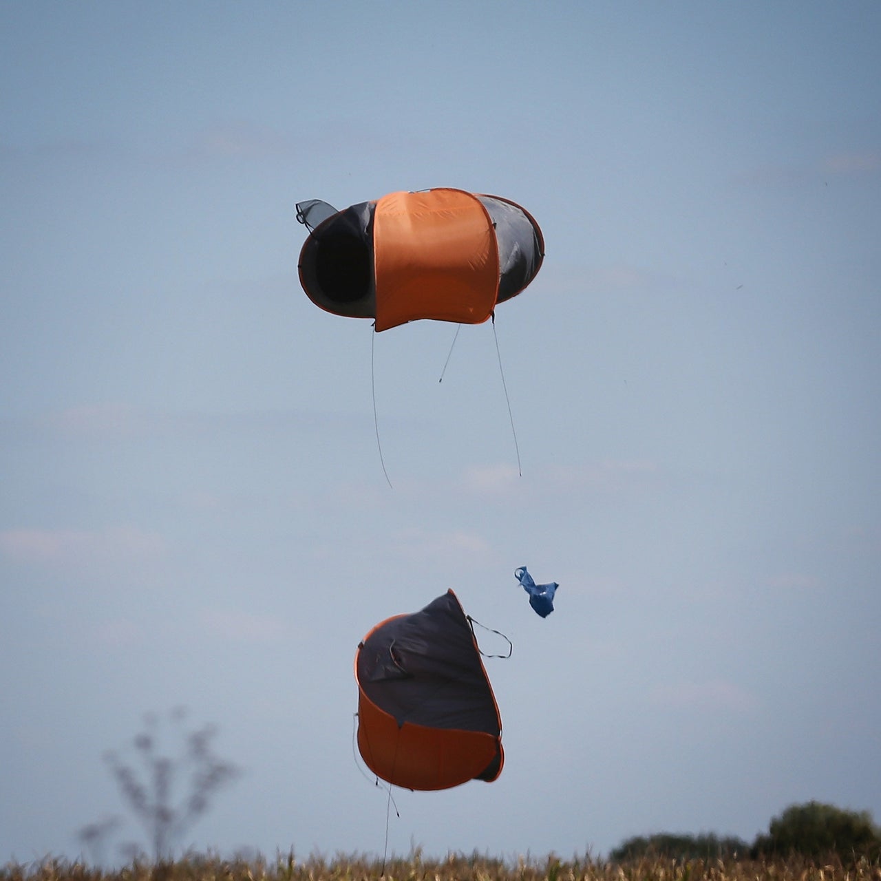 Discarded tents fly in the wind. 