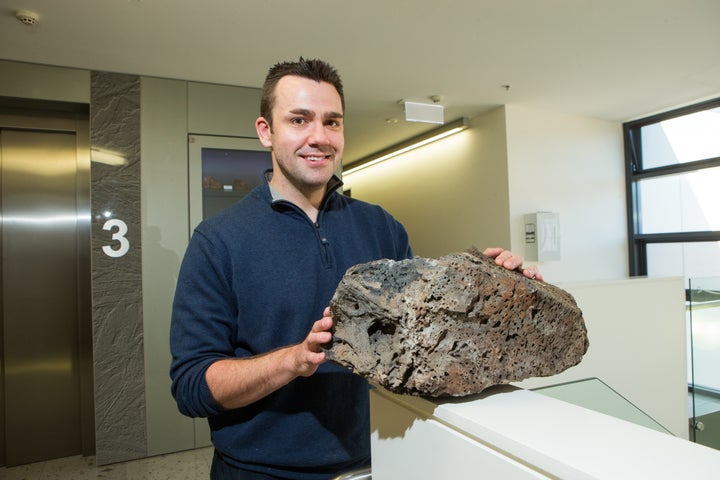 Dr. Rhodri Davies with a volcanic sample.