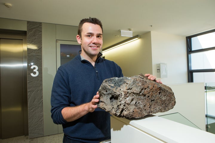 Dr. Rhodri Davies with a volcanic sample. 