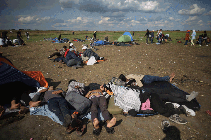 Exhausted migrants and refugees rest in a holding area after crossing the border from Serbia into Hungary near Roszke, on Sept. 6, 2015, and the same location on Sept. 16, 2015.