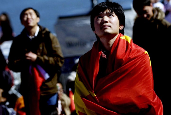 A student from China studying at Stanford University wrapped himself in a Chinese flag to stay warm at the start of the Olympic Torch relay route in San Francisco in April 2008.