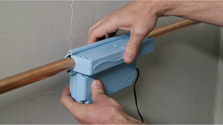 A user attaches the Fluid water meter onto a water pipe.