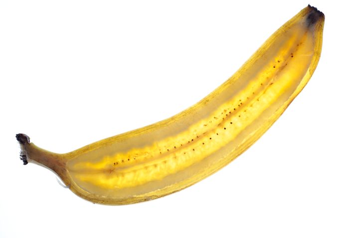 An ice cream banana with its peel still on, sliced in half 