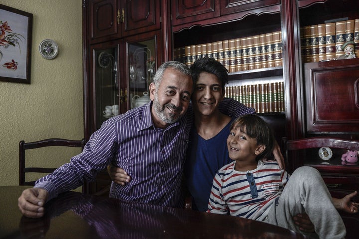 Osama Abdul Mohsen smiles with his 16-year-old son, Mohammed, and 7-year-old son, Zaid, at his apartment in Madrid, Spain, wh