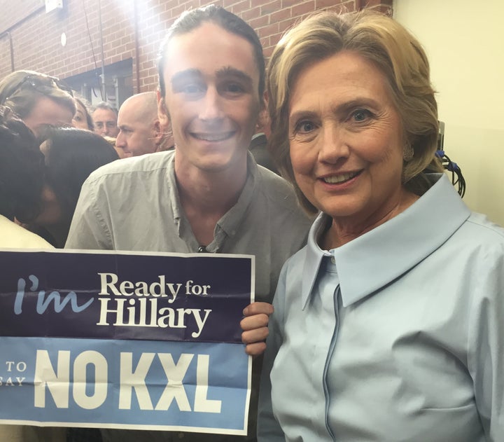 Hillary Clinton poses with anti-Keystone XL activist Griffin Sinclair-Wingate. Clinton said she'd soon tell the public what she thinks about the controversial pipeline.