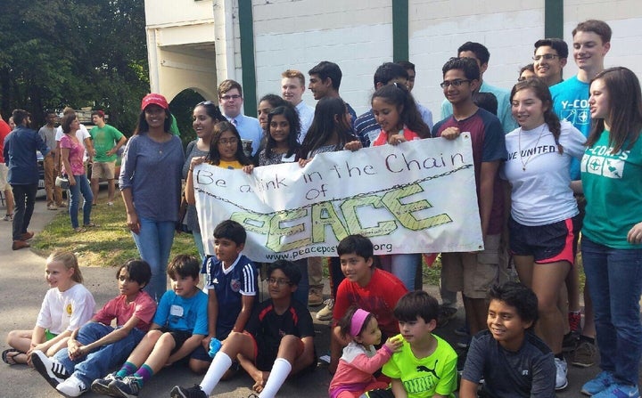 Louisville students hold a sign that reads: "Be a link in the chain of peace."