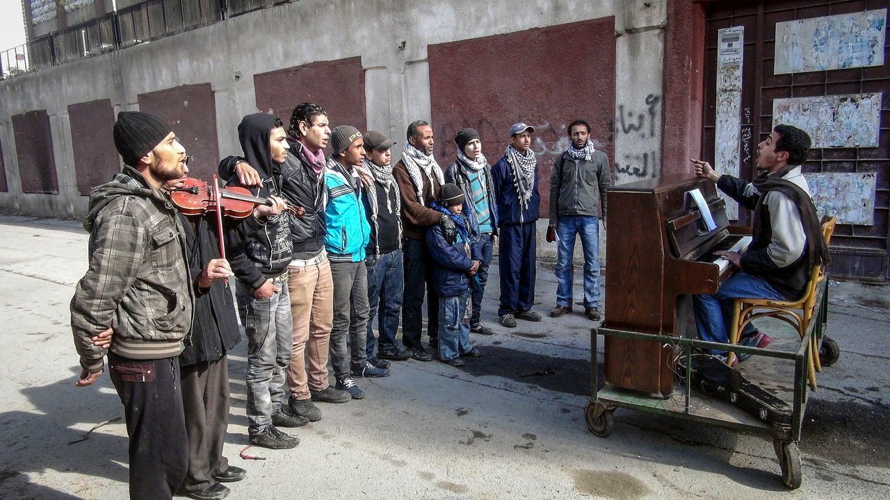 Ayham Ahmed plays the piano for his troupe of singers on the streets of Yarmouk, Syria, on Feb. 6, 2014.