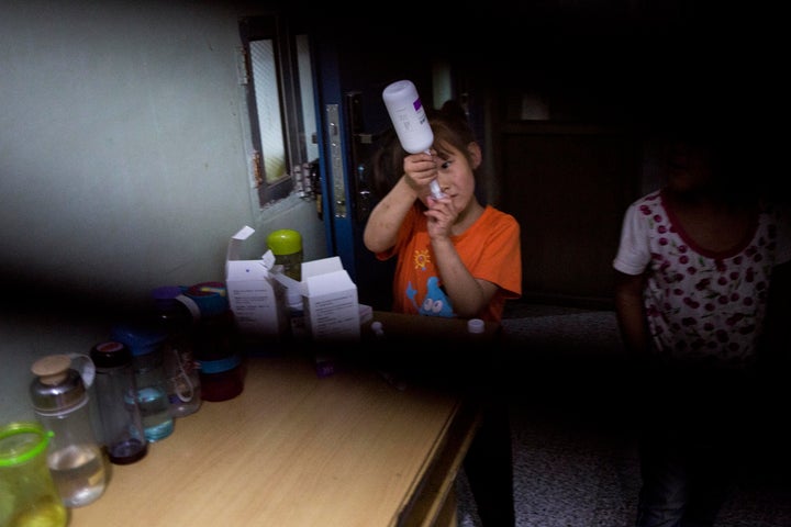 A third-grader takes her daily medication for HIV at Green Harbor.