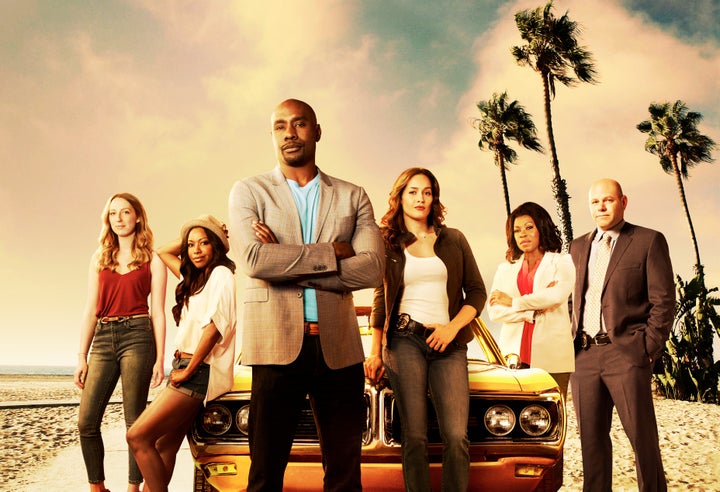 Morris Chestnut (center) and Jaina Lee Ortiz pose with the cast of "Rosewood."