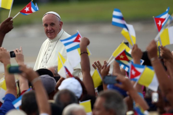 HAVANA, CUBA -- People wave Cuban and Papal flags as Pope Francis passes by as he arrives to perform Mass on September 20, 2015 in Revolution Square in Havana, Cuba.