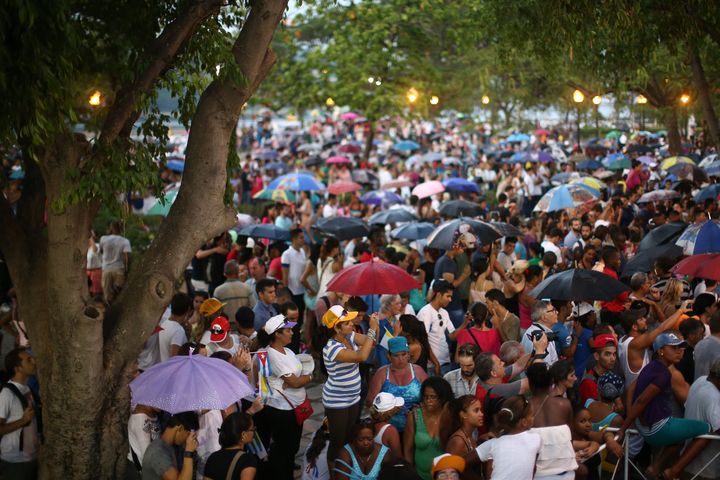 HAVANA, CUBA - SEPTEMBER 20: People shelter from the rain under umbrellas as they listen to a speech by Pope Francis following his visit to the Father Felix Varela cultural center on September 20, 2015 in Havana, Cuba. 