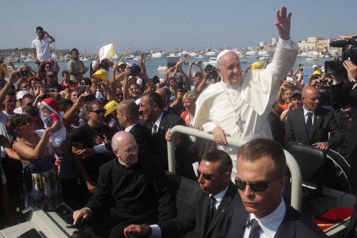 Pope Francis waves upon arrival during his visit to the island of Lampedusa, a key destination of tens of thousands of would-be immigrants from Africa, on July 8, 2013. 