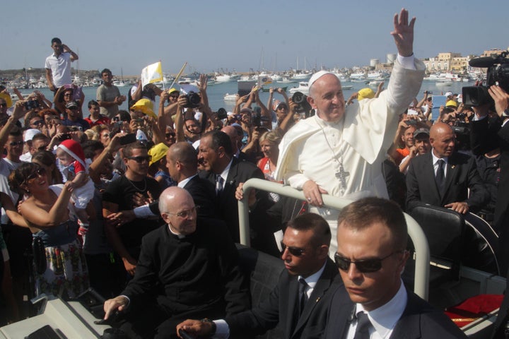 Pope Francis waves upon arrival during his visit to the island of Lampedusa, a key destination of tens of thousands of would-