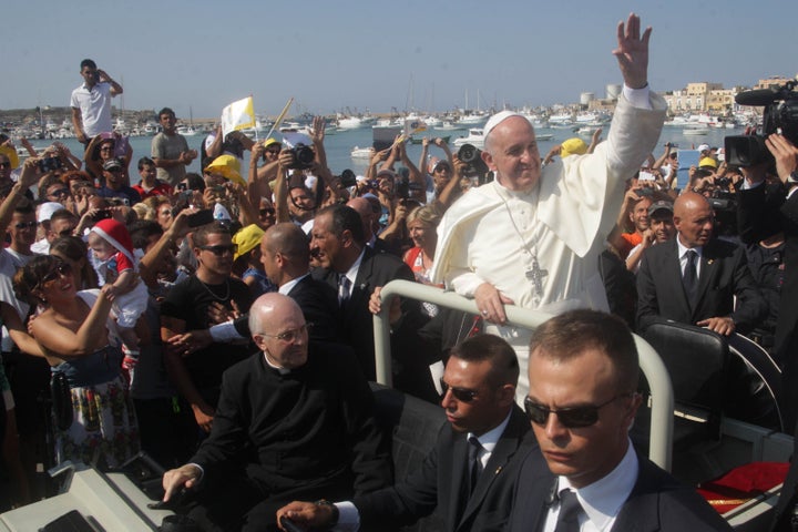 Pope Francis waves upon arrival during his visit to the island of Lampedusa, a key destination of tens of thousands of would-be immigrants from Africa, on July 8, 2013. 