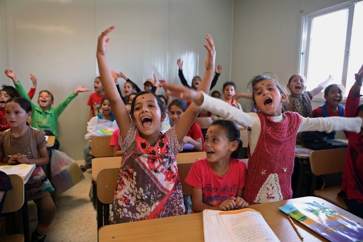 Syrian refugee students welcome as German Economy Minister Sigmar Gabriel visits the classroom during his visit at the Zaatari refugee camp near Mafraq, north of Amman, Jordan, Tuesday, Sept. 22, 2015.