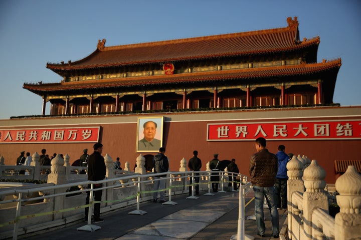 Plainclothes policemen guard in front of Tiananmen Gate outside the Great Hall of the People where the Communist Party's 205-