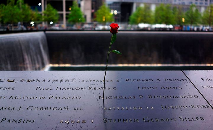A rose is placed on a name engraved along the South reflecting pool at the Ground Zero memorial site during the dedication ceremony of the National September 11 Memorial Museum in New York on May 15, 2014.