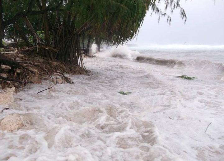 After a storm, flood waters gush toward Kiribati's mainland -- where Ioane Teitiota must return -- on March 14. The Pacific island is facing engulfment by rising sea levels caused by melting ice caps and expanding water particles from global warming.