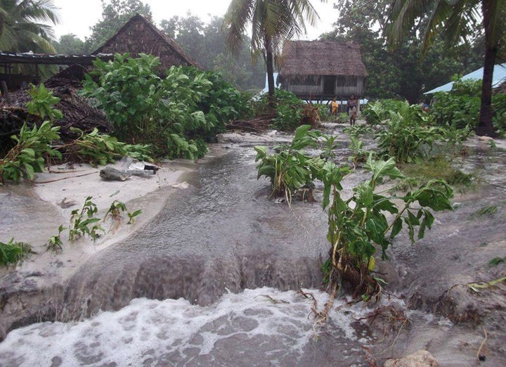 Flood water gushes through the island nation of Kiribati following a storm in March 14. The island nation faces extinction as rising water levels and storm cycles threaten to ravage and erode it.