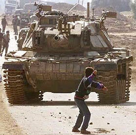 Faris Odeh, a fourteen-year-old boy, throwing stone at an Israeli tank ten days before he was shot and killed for stone-throwing by Israeli forces. 