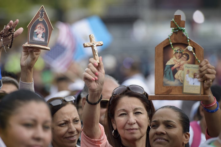 People hold up religious items while waiting for Pope Francis at Independence Hall on September 26, 2015 in Philadelphia, Pennsylvania. 