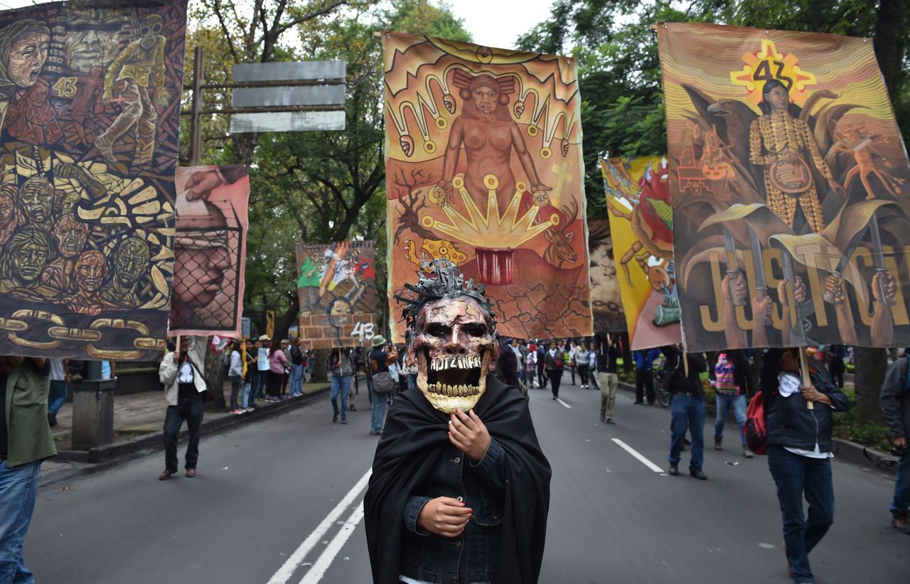 Thousands commemorate the first anniversary of the students' disappearance by marching in Mexico City.