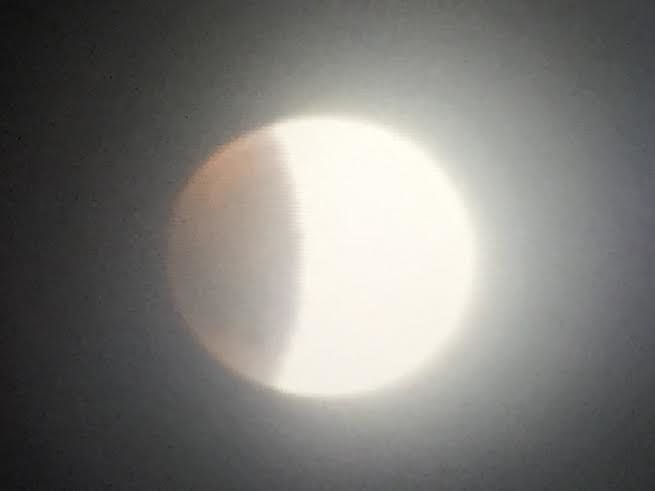 This iPhone picture of the camera screen of my Nikon shows that the dark part of the moon, the eclipsed part, is glowing faintly reddish, like the color of raspberry sherbet. The unexposed part of the moon is overexposed here. -- Dr. Jay Pasachoff, astronomy professor at Williams College