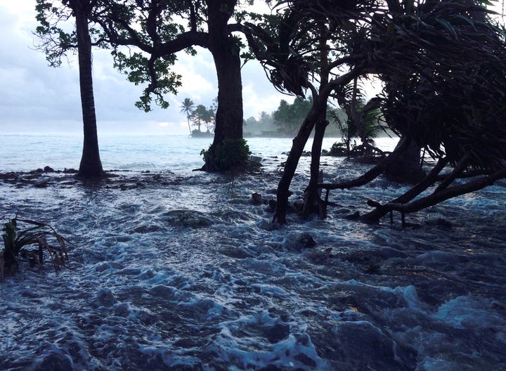 A high tide energized by storm surges washes across Ejit Island in Majuro Atoll, Marshall Islands, causing widespread flooding and damaging a number of homes.