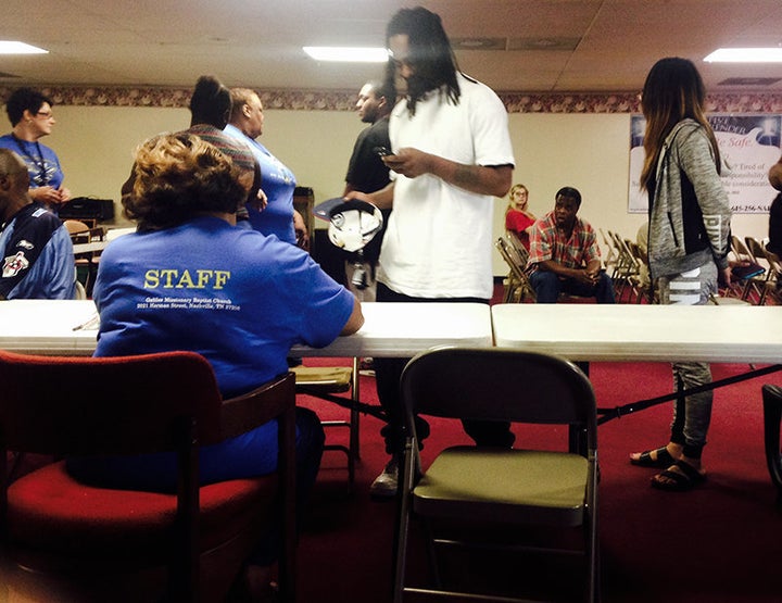 A volunteer assists Fugitive Safe Surrender participants and their accompanying friends and family navigate the program on Se