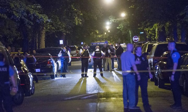 Chicago police investigate a shooting scene where five people, including an 11-month-old child, were killed or injured on Sept. 28, 2015.
