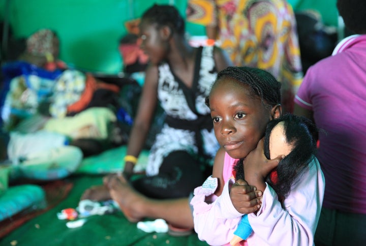 Five-year-old Nema Shukuru from Congo hugs her doll in a refugee camp set up on a sports field in Isipingo Township on April